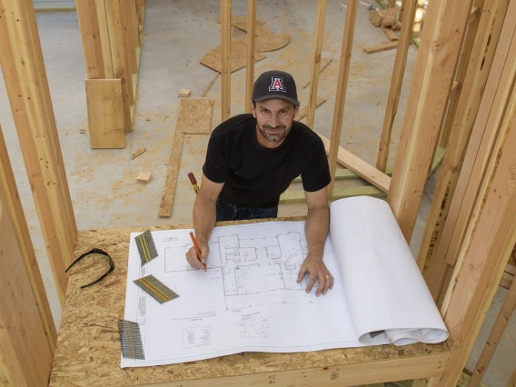 Todd Vanderah references blueprints at a construction site.