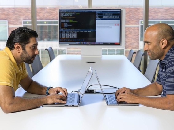 Syed Shujaat Ali Zaidi, PhD, (left) and Rudramani Pokhrel, PhD (right), sit a table with their laptops.