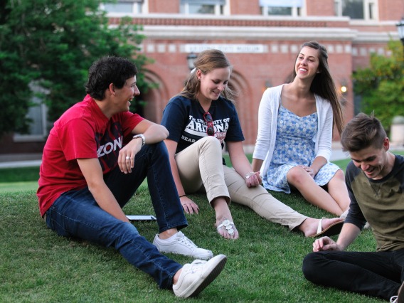 Students hanging out on a campus lawn