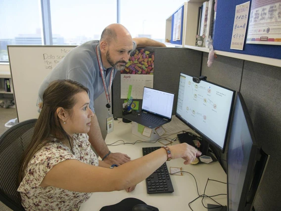 Data Science Fellow Luisa Rojas sits at a computer sharing information with her research advisor, Jonathan Lifshitz, PhD.