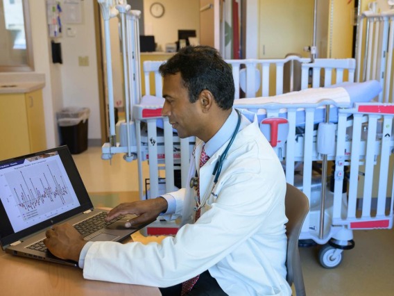 Ajay Perumbeti, MD, pediatric hematologist oncologist, views data on his laptop. 