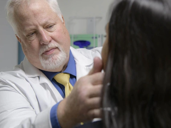 Kevin Lohenry, PhD, PA-C, examines a patient.