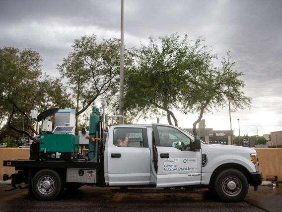 an industrial pickup truck sitting in a parking lot beneath a cloudy sky